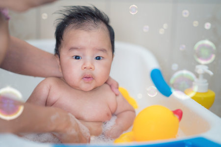 Asian baby bath with mother and duck toy and bubble