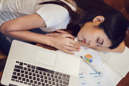 Student in university sleeping after finish home worke on the desk with computer notebook, This immage can use for over work, education, job, business, work hard, study and exam conceptの写真素材
