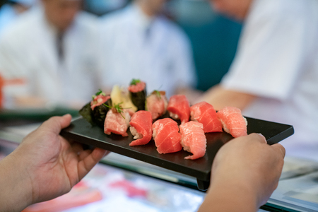 Customer take Salman Shushi from chef in Japanese sea food restaurantの写真素材