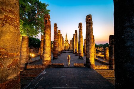 Sunset and light in Sukhothai historical park and wat Sri chum with Asian traveller walking on the temple, this image can use for travel, Bangkok, Thailand and landmark in aisa conceptの写真素材