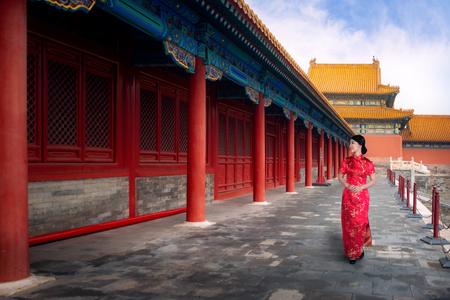 Chinese lady walk in red cheongsam dress in ancient Chinese forbidden palace, Beijing city, China, Asia. This photo can use for Travel in China asnd Asia conceptのeditorial素材