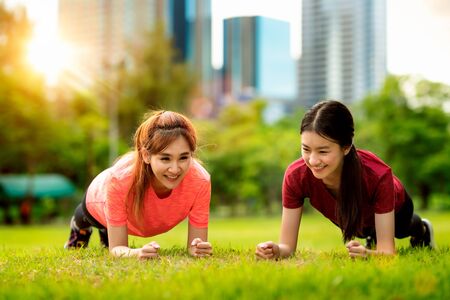 Fitness Asian woman doing push ups during outdoor cross training workout. Beautiful young and fit fitness sport model training outsideの写真素材
