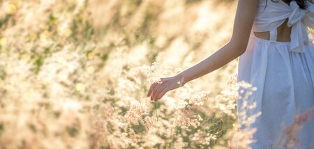 Beauty Asian Girl Outdoors enjoying nature. Beautiful Teenage Model girl in white dress running on the Spring Field, Sun Light.の写真素材