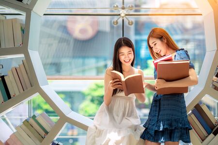 Asian girl student read a textbook in library in her University, this image can use for education, learn, Business, and college conceptの写真素材