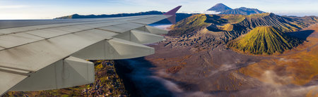 Wing of airplane and view of mountain Bromo volcano from view of airplane windows, Java island,...