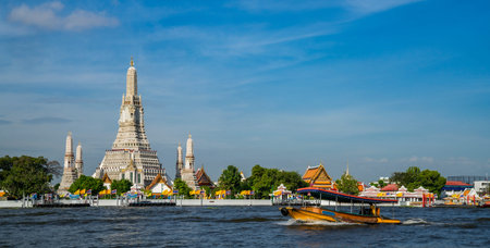 Wat Arun temple with river and transportation boat in Bangkok city, Bangkok, Thailand