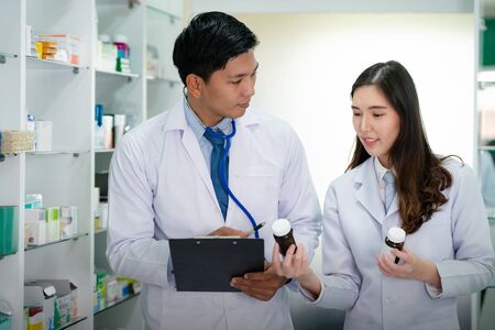 Asian Doctor and Asian Pharmacist girl discust abour type of medicine in Hospital, this photo can use for business, clinic, health, drugstore, drug and phamacy storeの写真素材