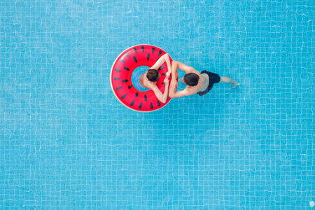 Asian couple in love in swimming pool on summer time, this image can use for valentine day, resort,...