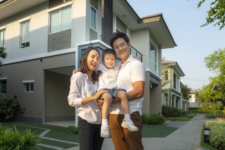 Beautiful family portrait smiling outside their new house with sunset, this photo can use for family, father, mother and home conceptの写真素材