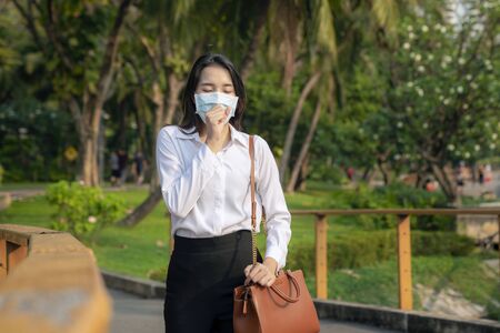 Asian girl use a protection mask for prevent PM 2.5 and corona viruus or covic 19 in park of Bangkok cityの写真素材