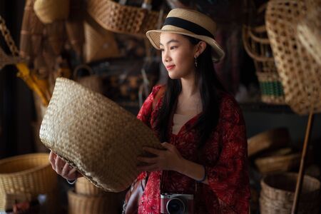 Asian girl, travel and shopping in traditional basketry shop in Thailand old market.の写真素材