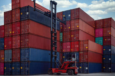 Stack of container box in transportation port with container lift car, this image can use for shipping, container, delivery and business conceptの写真素材