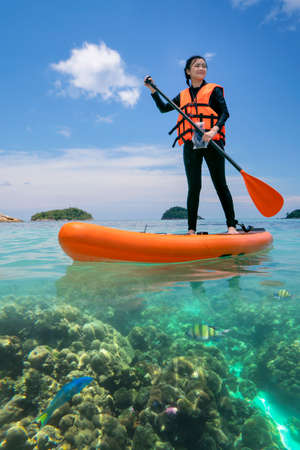 Asian woman relax on the beach with SUP BOARD at lipe island in summer season, Thailandの写真素材
