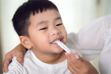 Mother  uses an antigen test kit  on her sonの写真素材