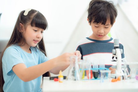 Asian boy and girl play and education together in living room, they play text block together in class room in preschoolの写真素材