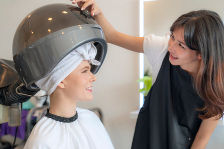 European woman hairdresser in beauty salon cut hair and hair design to her customerの写真素材