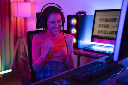 Asian woman gamer play online game with joystick and computer, E sport team at game center under they streaming they tournamentの写真素材