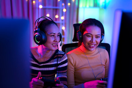 Asian woman gamer play online game with joystick and computer, E sport team at game center under they streaming they tournamentの写真素材