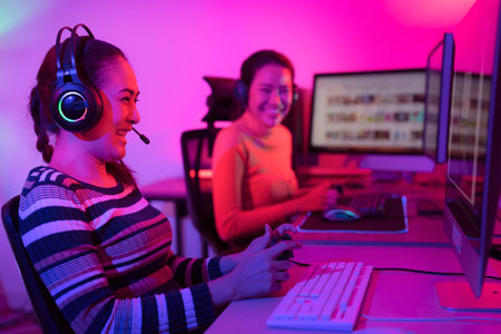 Asian woman gamer play online game with joystick and computer, E sport team at game center under they streaming they tournamentの写真素材