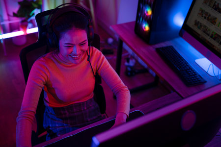 Asian woman gamer play online game with joystick and computer, E sport team at game center under they streaming they tournamentの写真素材