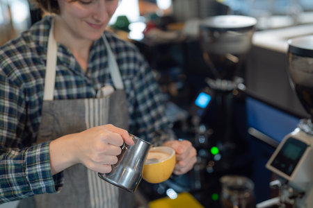 Women barista in an apron making coffee with coffee maker machine in a coffee shopの写真素材