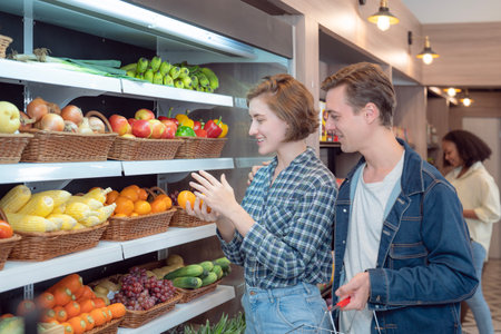 Couple shopping vegetable togather  on shelf in freezer in convenience storeの写真素材