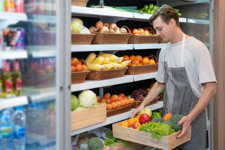 American man grocery working in supermarket with fruit and vegetable background, owner business man for shopping storeの写真素材