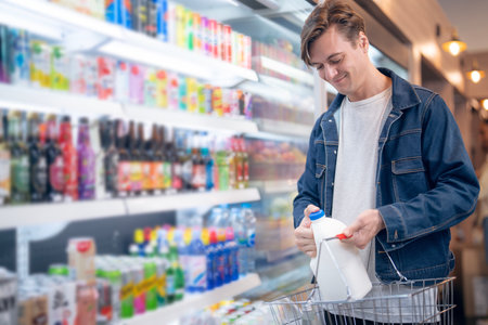 An European man but a bottle of milk from refrigerator cold in onvenience store for drink at homeの写真素材