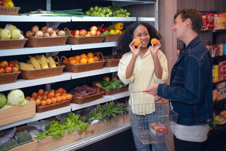 Couple shopping orange and vegetable togather on shelf in freezer in convenience storeの写真素材