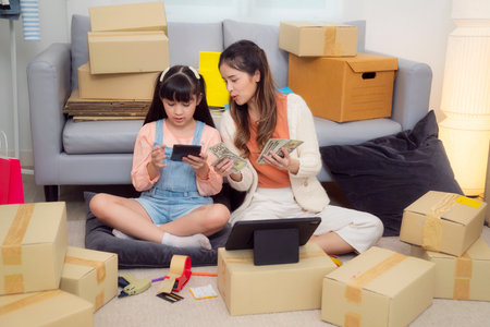 Mother and her daughter packing and sell online togather at home by use internet and on line marketing, Family SME business at homeの写真素材