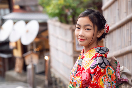 Japanese tourist girl in red Kimono traditional dress walking in walking street at Gion Temple area, Kyoto city, Japanの写真素材