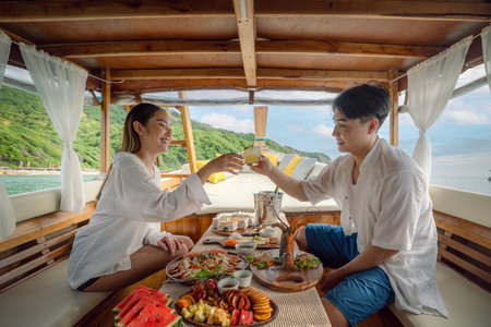 Asian couple lover travel and relax in they honeymoon trip on the wooded boat and eat seafood togather at Koh phi phi island, Maya beach, Phang nga near Phuket in Thailandの写真素材