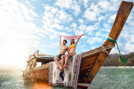 Asian couple lover travel and relax in they honeymoon trip on the wooded boat at Koh phi phi island, Maya beach, Phang nga near Phuket in Thailandの写真素材