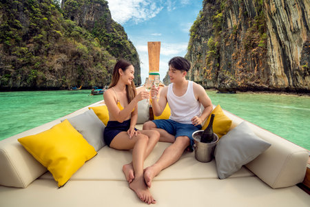 Asian couple lover travel and relax in they honeymoon trip on the wooded boat at Krabi, Phi Phi island, maya bay, Thailandの写真素材