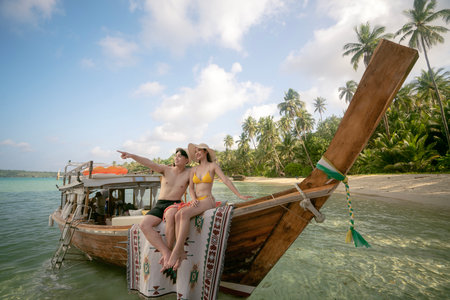 Asian couple lover travel and relax in they honeymoon trip on the wooded boat at Koh phi phi island, Maya beach, Phang nga near Phuket in Thailandの写真素材