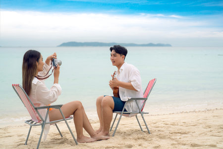 Asian traveller couple sitting and see sunset togather on the beach with longtail boat background at Phi phi island maya beach near Phuket, Thailandの写真素材