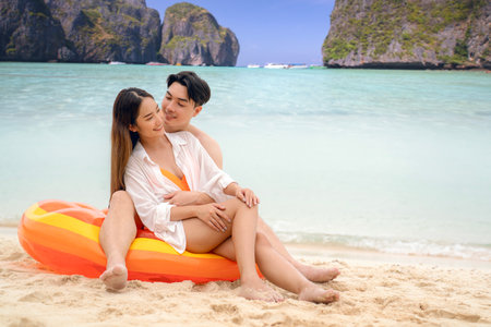 Asian traveller couple playing and sweet togather on the beach between honeymoon day at Phi phi island maya beach near Phuket, Thailandの写真素材