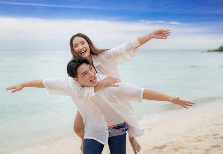 Asian traveller couple playing and sweet togather on the beach between honeymoon day at Phi phi island maya beach near Phuket, Thailandの写真素材