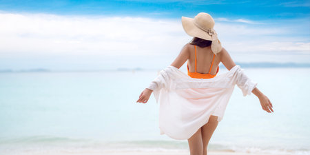 Asian tourist woman in orange bikini on the beach at Phi Phi island in Phuket, Thailandの写真素材