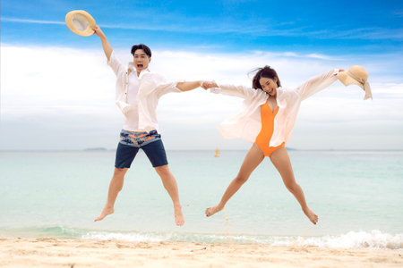 Asian traveller couple playing and sweet togather on the beach between honeymoon day at Phi phi island maya beach near Phuket, Thailandの写真素材