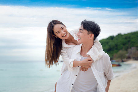 Asian traveller couple playing and sweet togather on the beach between honeymoon day at Phi phi island maya beach near Phuket, Thailandの写真素材