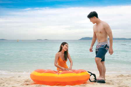 Asian traveller couple playing and sweet togather on the beach between honeymoon day at Phi phi island maya beach near Phuket, Thailandの写真素材