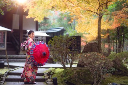 Asian traveler girl in Kimono traditional dress walking in old temple in Autumn season in Kyoto city, Japanの写真素材