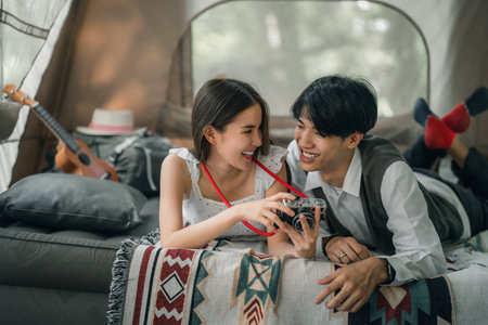 Asian couple sweet in tent inside on they camping trip, traveller relax and sleep togather in out door and camping tripの写真素材