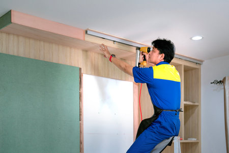 Asian worker and staff of home builder company under working and renovate build-in furniture in living room at new homeの写真素材