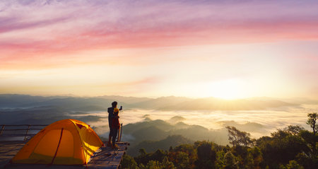 Asian couple enjoy in they tent at they camping point with morning sunrise view, fog and mountain view, land scape of Doi mon kalakojo at Tak near Chiang mai, Thailandの写真素材