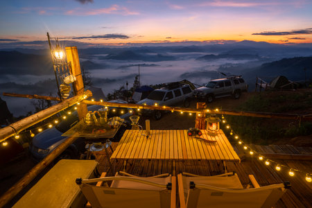 Table Stove and chair in camping  and tent with sunrise and fog on the mountain in winter season at Tak, Thailandの写真素材