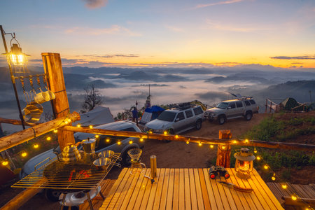 Table Stove and chair in camping  and tent with sunrise and fog on the mountain in winter season at Tak, Thailandの写真素材