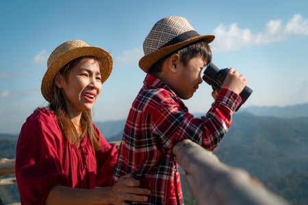 Asian mother and her son enjoy in travel trip in Chiangmai family trip with binocular and mountain backgroundの写真素材