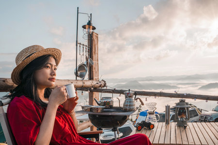 Asian woman traveller relax in camping at Tak, north of Thailand, Tent travel in Chiang mai with fog and mountain in morning time backgroundの写真素材